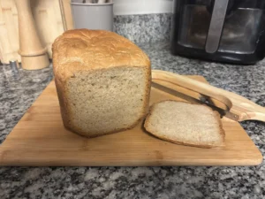 Soft homemade bread slice showing fluffy interior crumb next to full loaf on cutting board