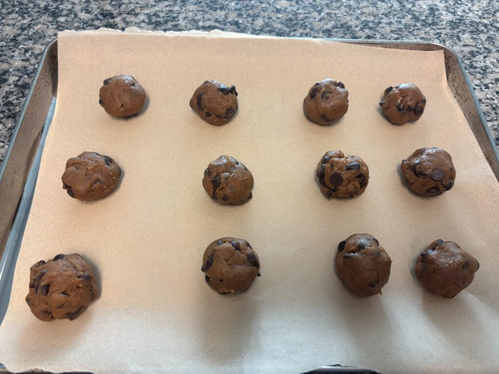 Brown butter chocolate chip cookie dough balls ready to bake on parchment paper